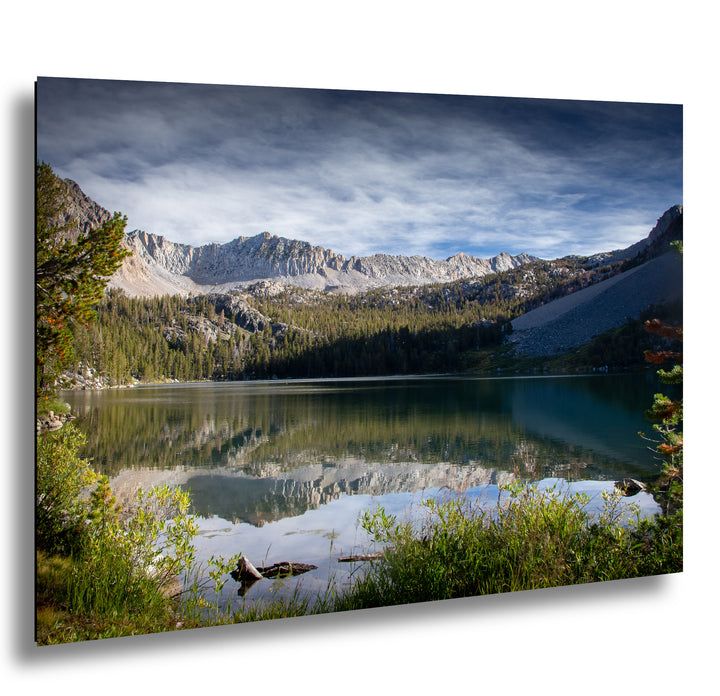 Mountain lake reflection with granite peaks, alpine forest, and wildflowers landscape photography.
