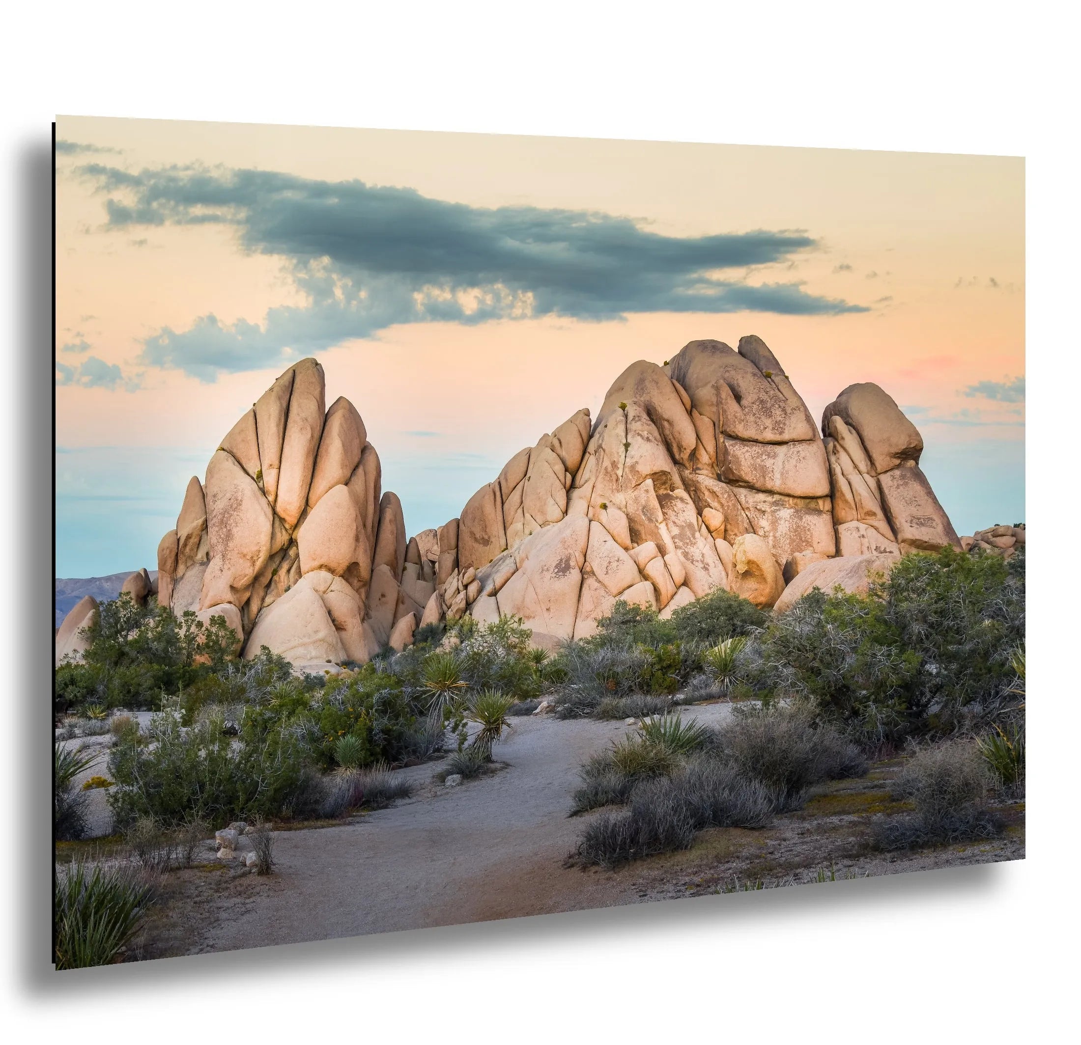 Joshua Tree National Park massive granite rock formations at sunset with desert scrub vegetation and colorful sky.