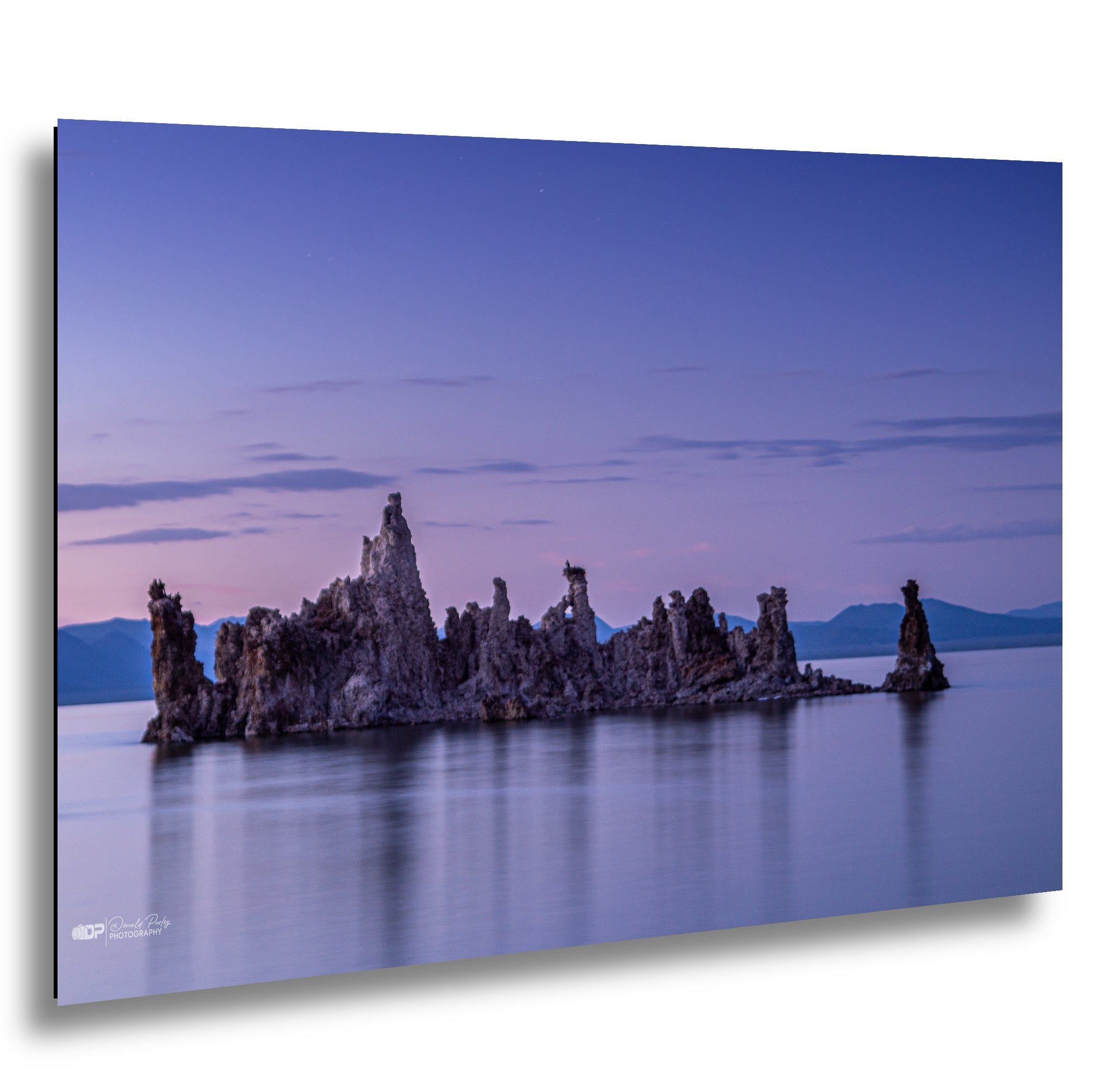 Mono Lake tufa towers at twilight with purple and blue-sky reflection in calm.