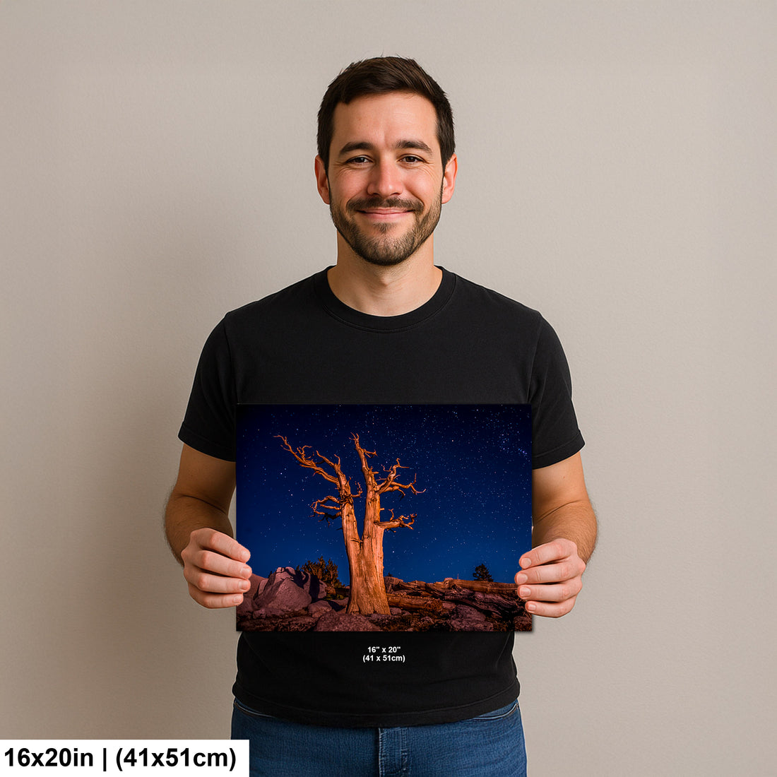 Photographer holding 16x20 inch bristlecone pine starry night print on neutral background.