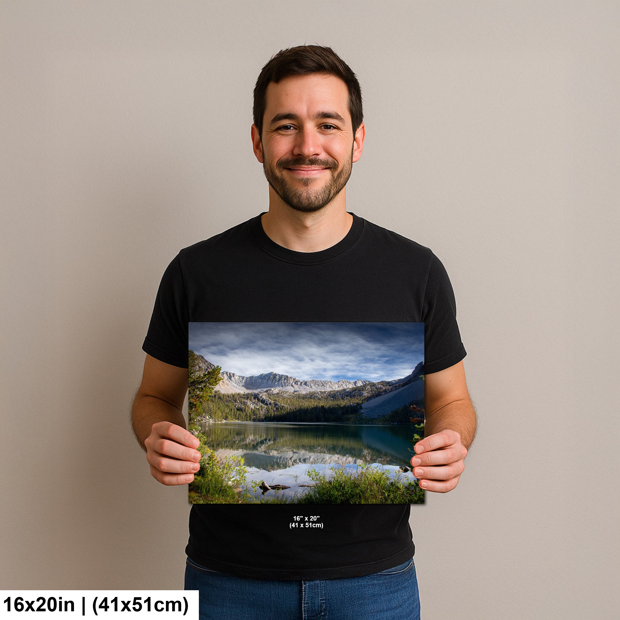 Man holding alpine lake reflection with granite mountains and forest landscape photography print.
