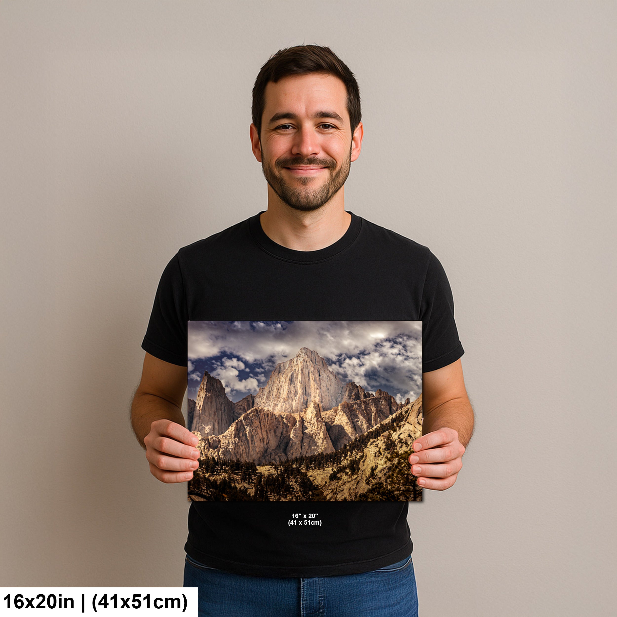 Man holding Yosemite El Capitan granite monolith and valley landscape photography print with cloudy sky.
