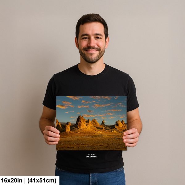 Photographer holding 16x20 inch Trona Pinnacles golden hour print on neutral background.