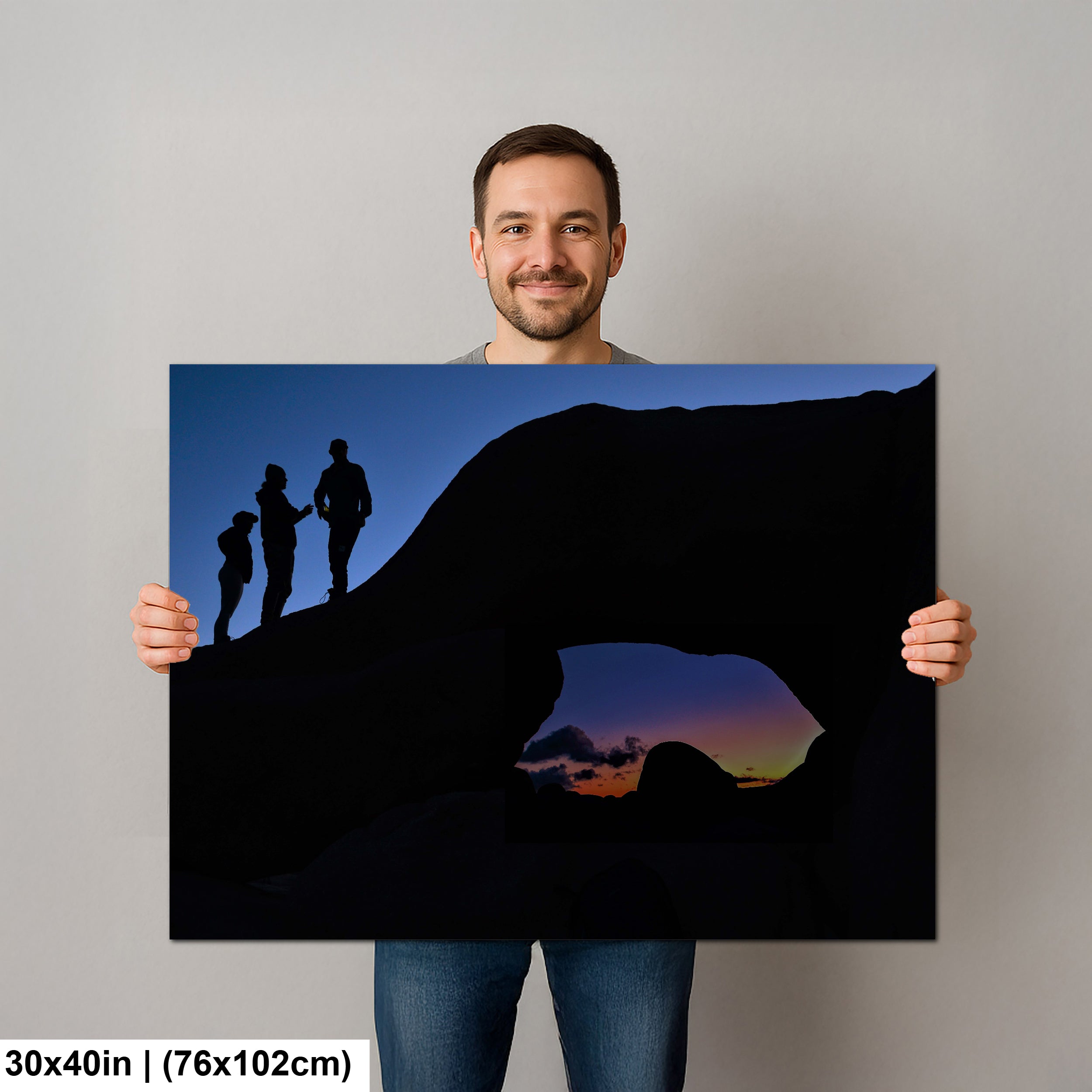 Silhouette of Arch Rock with silhoutte of people on top in Joshua Tree National Park
