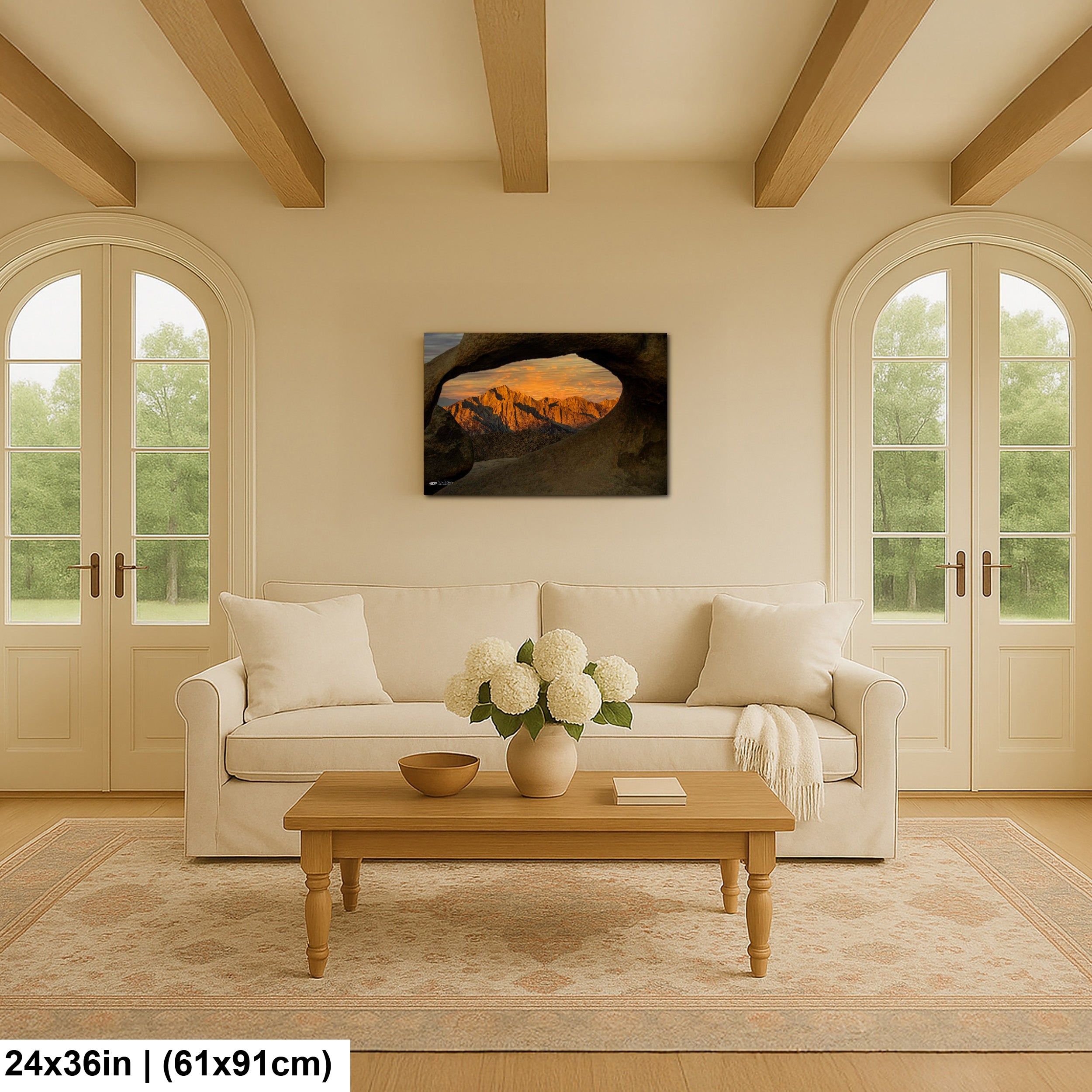 Joshua Tree sunset rock window landscape canvas above cream sofa in modern farmhouse living room with arched doors.