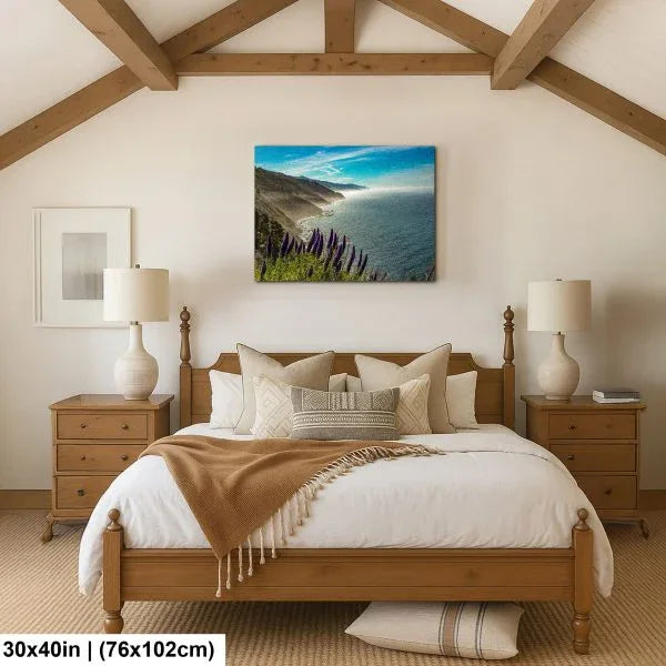 Alpine mountain stream and meadow landscape canvas above white sofa in coastal farmhouse living room.