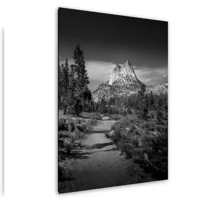 Black and white mountain peak and alpine stream landscape photography with conifer forest.